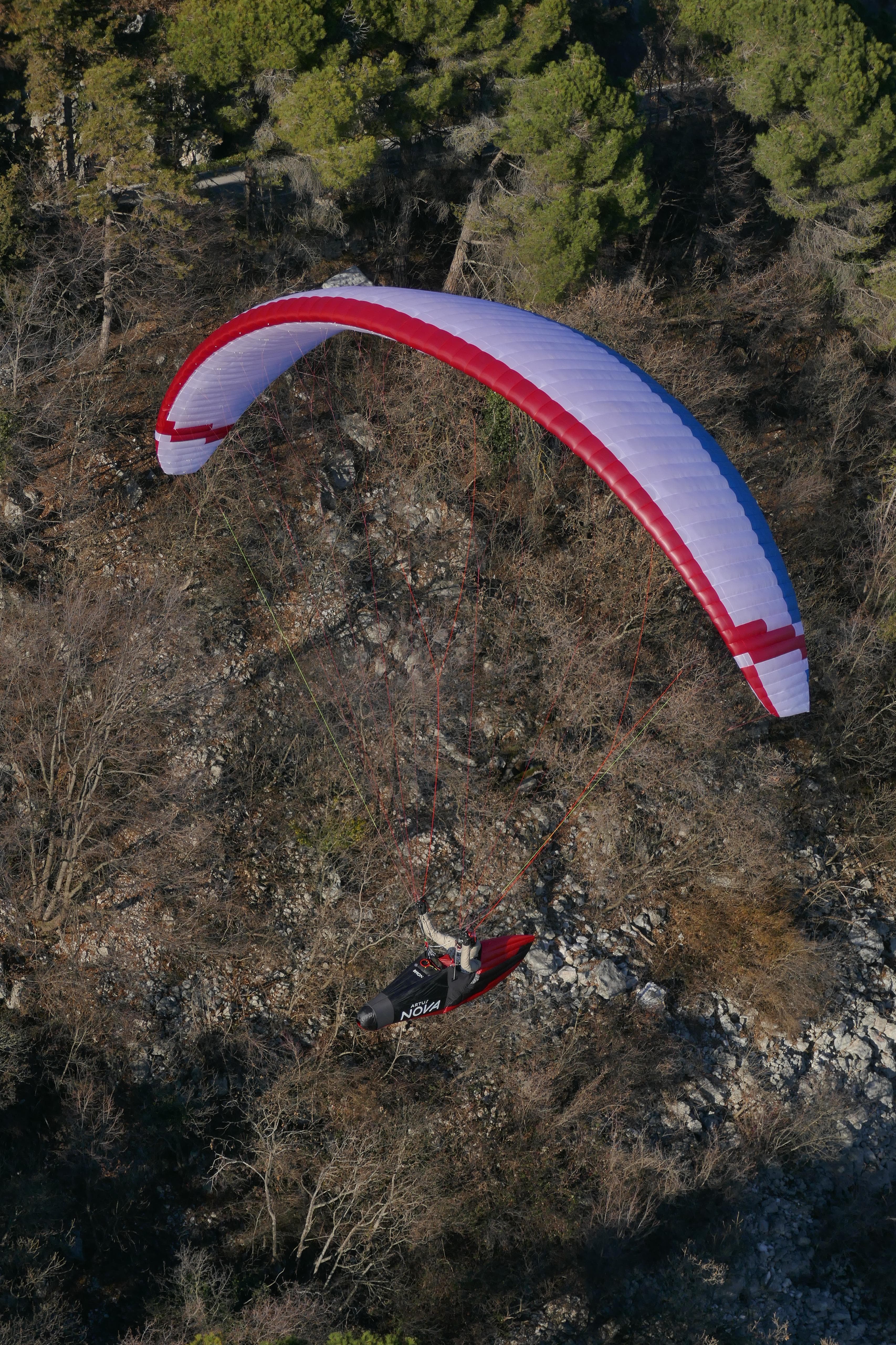 Tanner im Gleitschirm, aus der Ferne zu sehen nah an einem Hang