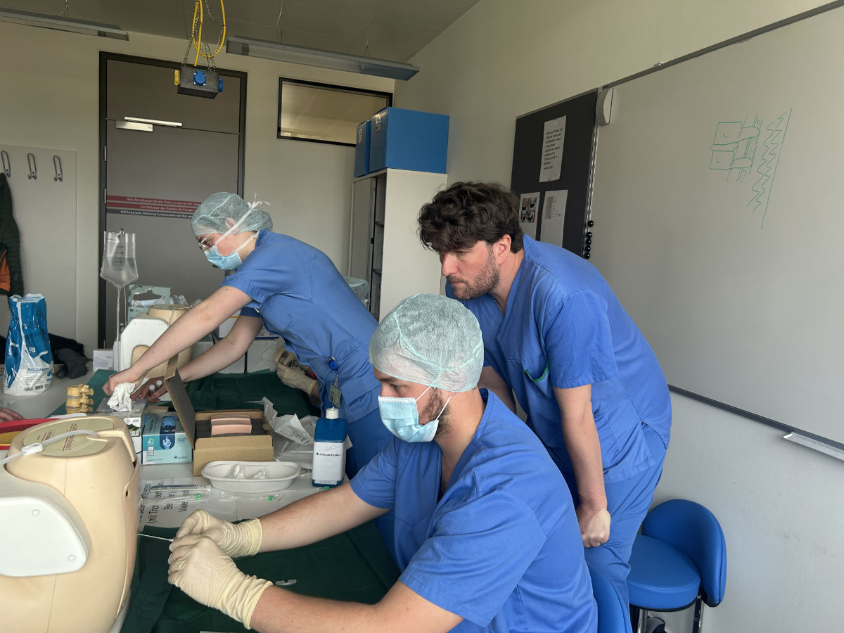 Benjamin Hetzer, ärztlicher Leiter des Skills Lab, übt mit den TeilnehmerInnen eine Lumbalpunktion.