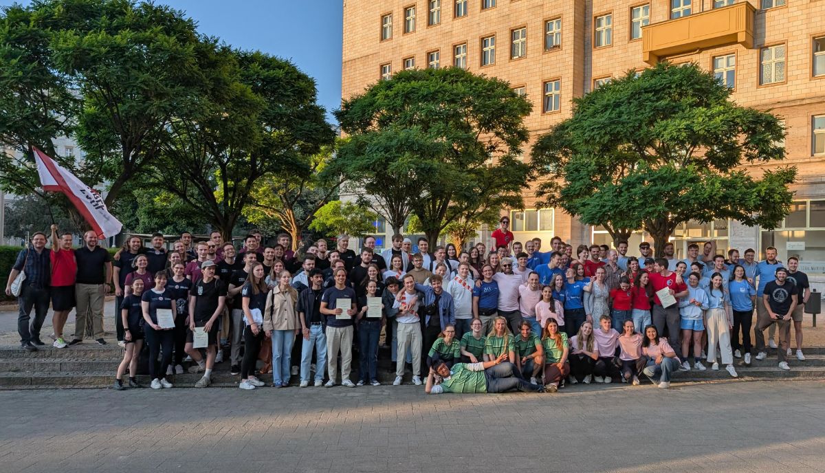 Gruppenfoto mit allen Teams und TeilnehmerInnen des PEC mit Urkunden und Flagge des PEC